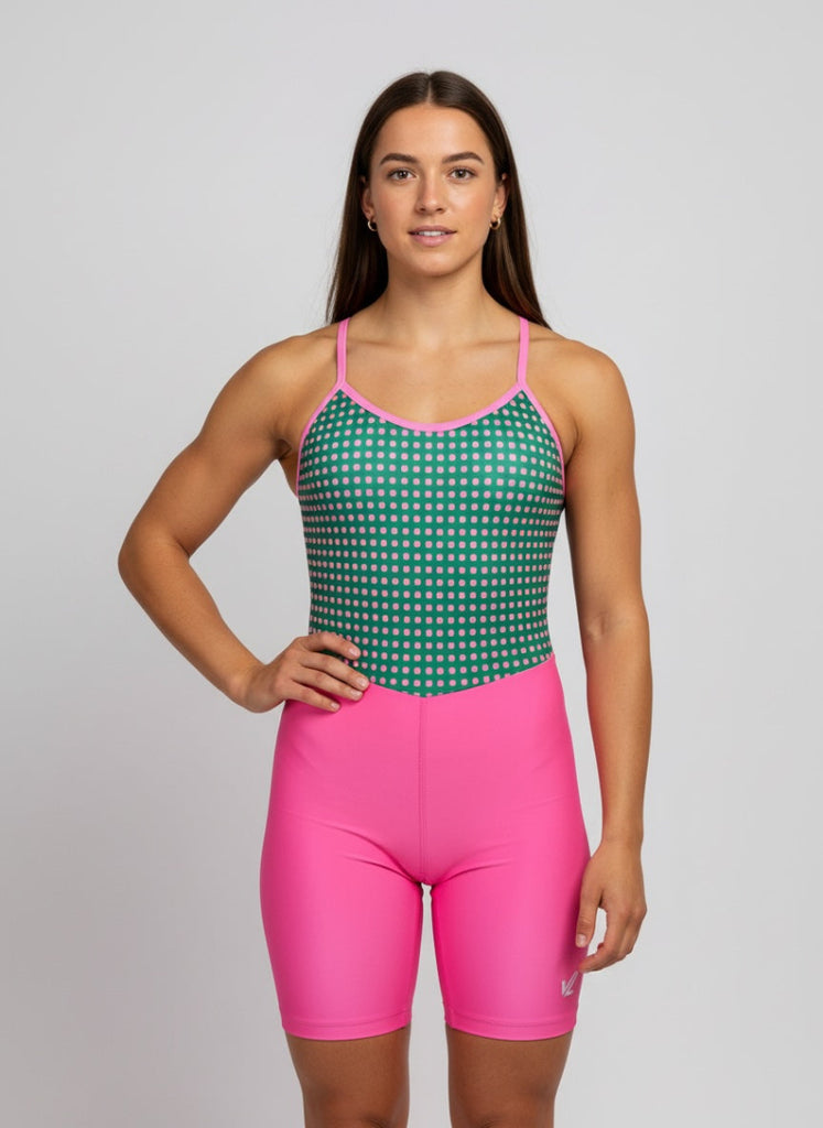 Woman wearing a green and pink rowing uni with a polka dot top and pink shorts 