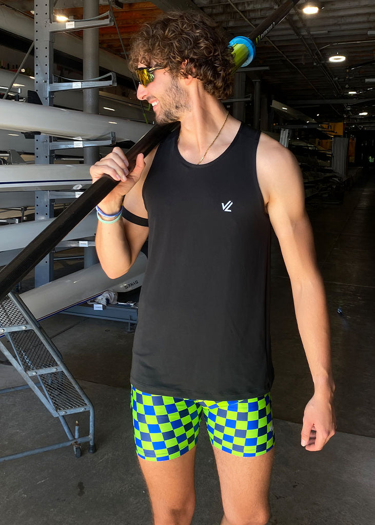 JL Racing model wearing a black tank top and green checkered trou shorts holding a oar.