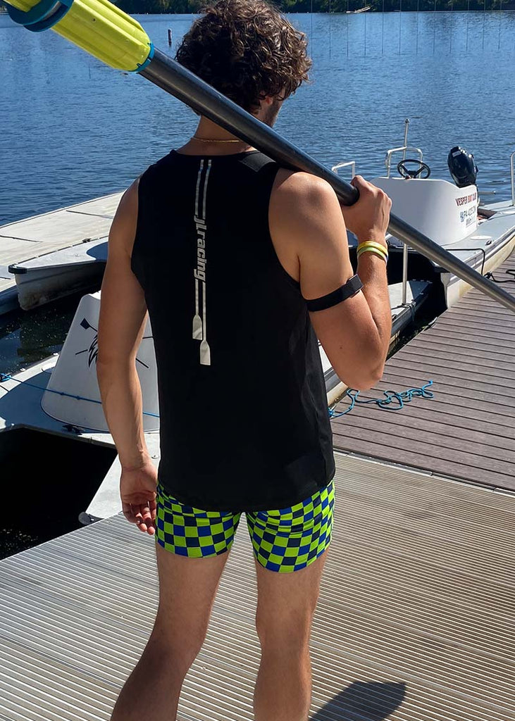 JL Racing model wearing a black tank top and green checkered trou shorts holding a oar.