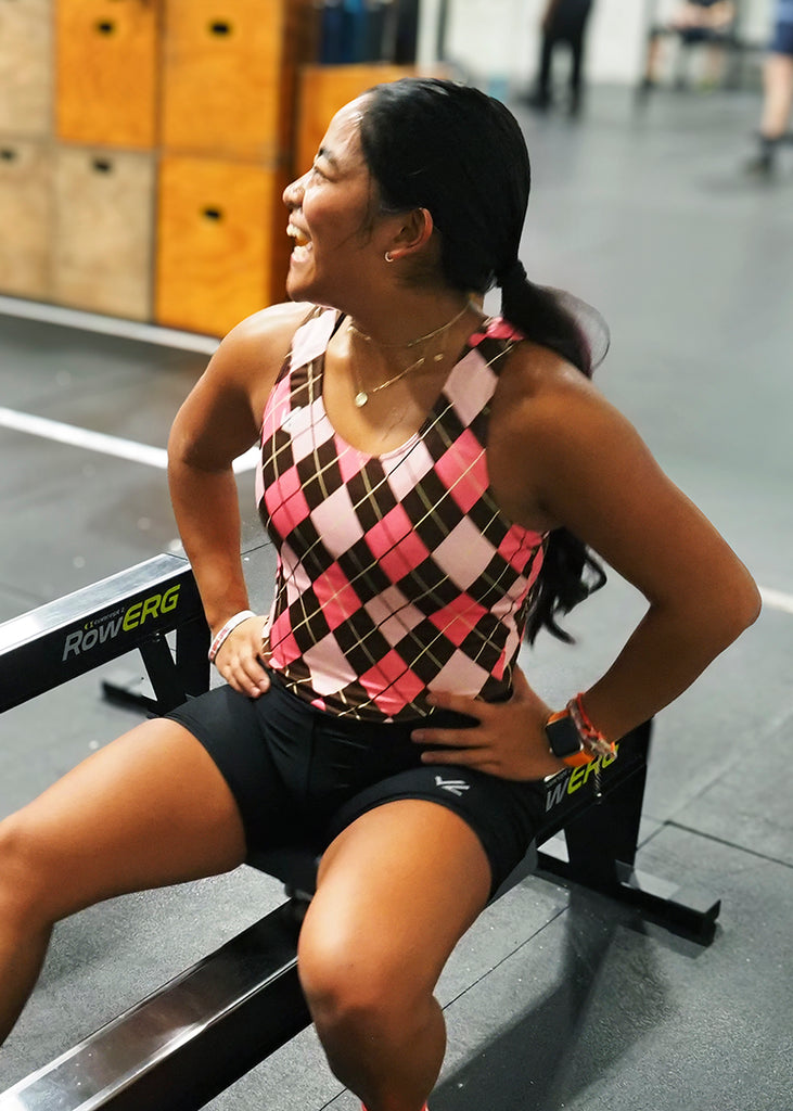 Woman wearing a JL Women's Totally Argyle Unisuit on a row machine in a gym