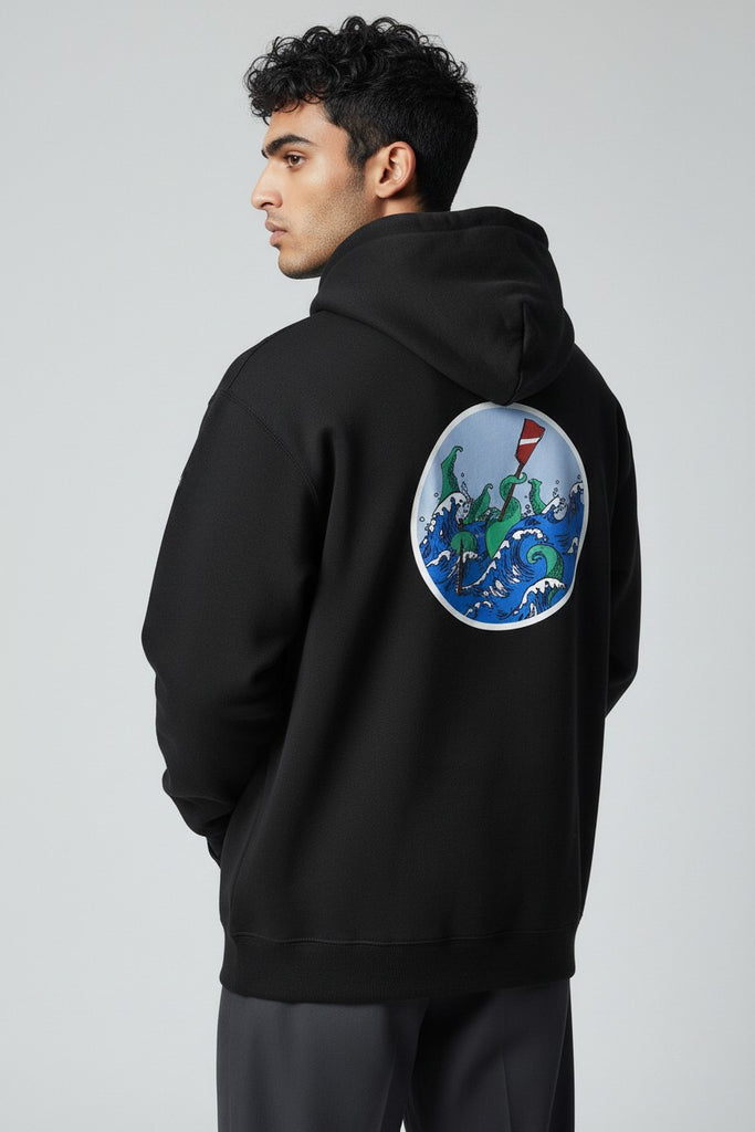 Man wearing a black hoodie with a colorful ocean graphic on the back