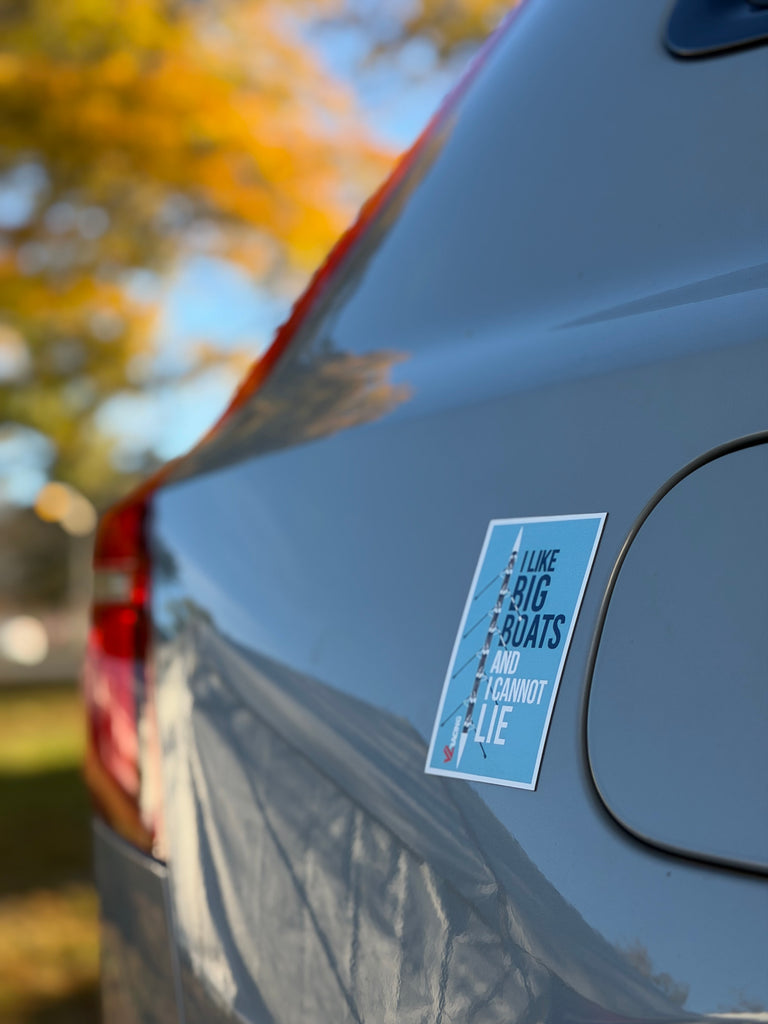 Car with a magnet on the side, outdoors with trees in the background