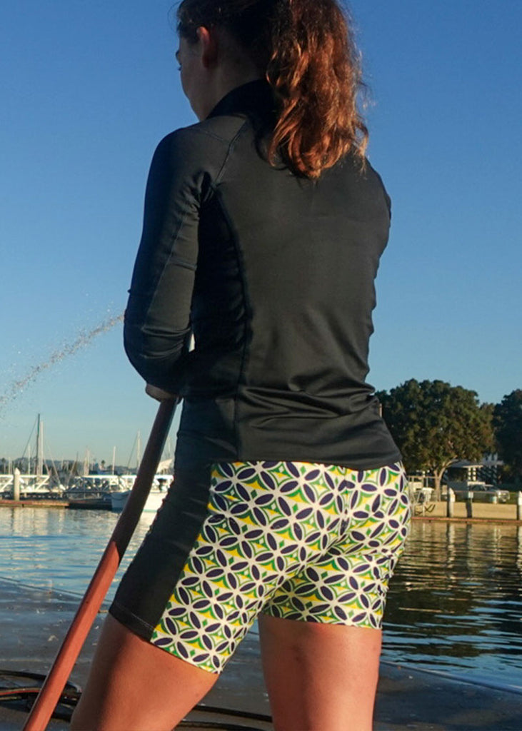 Person wearing  JL Women's Mosaic Banded Trou with an oar in her hand near the water